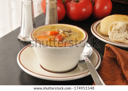 A cup of chicken soup with wild rice and carrots