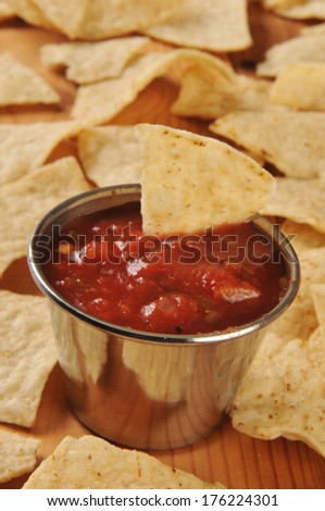 Fried tortilla chips with salsa - shallow depth of field, focus on front of salsa tin
