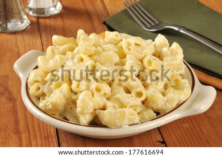 A bowl of parmesan macaroni and cheese on a rustic wooden table