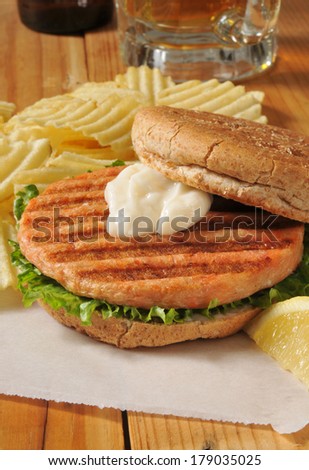 A grilled salmon burger with chips and beer