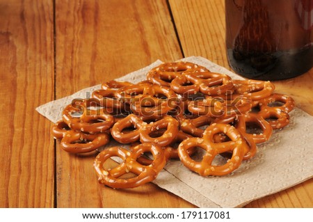 Salted pretzels on a bar napkin with a bottle of beer