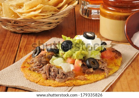 Beef and bean tostadas with cheddar cheese, black olives, sour cream and guacamole