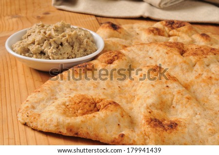 Hot naan bread with a side of black olive hummus