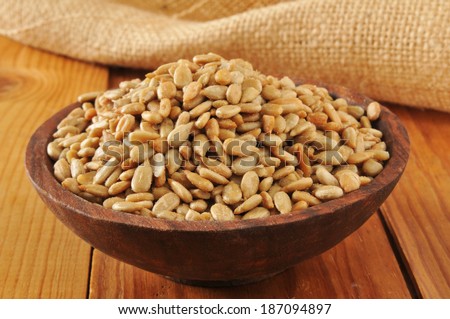 A wooden bowl of roasted, salted sunflower seeds