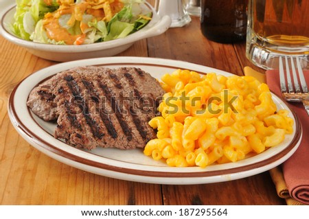 Grilled cube steak with macaroni and cheese and a mug of beer