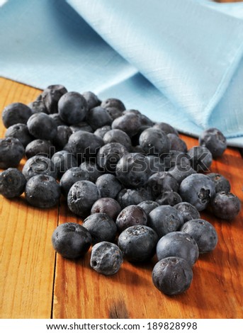 Fresh organic blueberries on a wooden table with a linen napkin