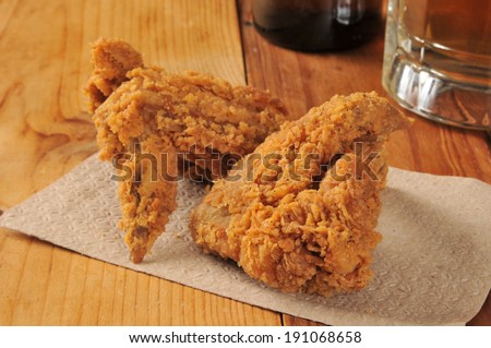 Fried chicken wings on a bar napkin with a mug of beef