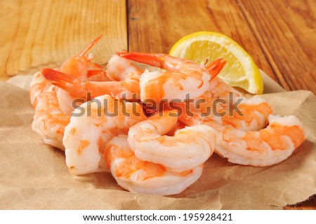 Shrimp prawns on butcher paper with a wedge of lemon