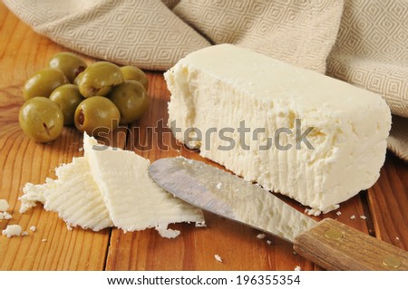 A block of feta cheese with stuffed green olives