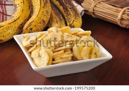 a bowl of dried banana chips on a wooden table