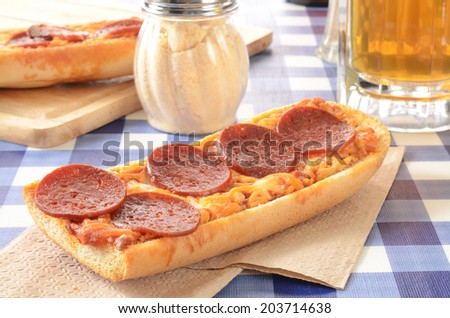 French bread pizza on a picnic table with a mug of beer