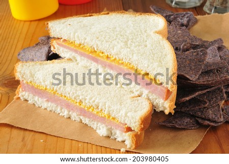 A ham and cheese sandwich with blue corn tortilla chips