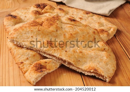 Sliced naan bread on a rustic wooden cutting board