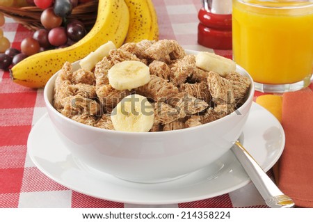 A bowl of shredded, organic wheat cereal with banana slices