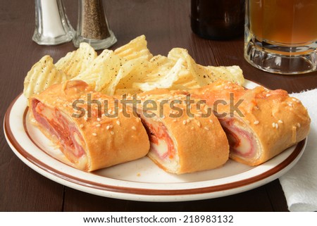 A bread roll stuffed with Italian meats and cheeses with sea salt and pepper potato chips