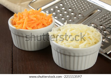 Small bowls of grated cheddar and swiss cheeses