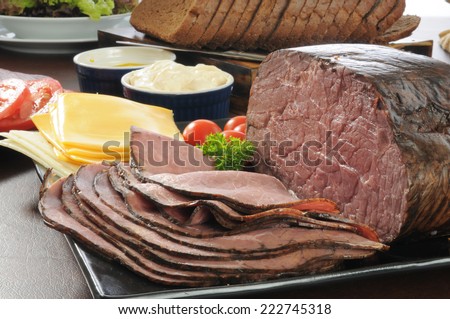 Thin sliced roast beef with cheese, bread and other sandwich fixings