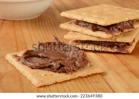 Graham crackers with chocolate frosting on a wooden table