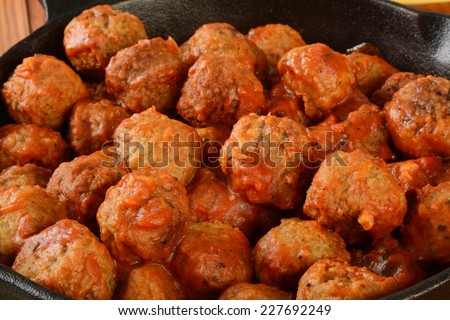 Closeup of Italian meatballs in marinara sauce in a cast iron skillet