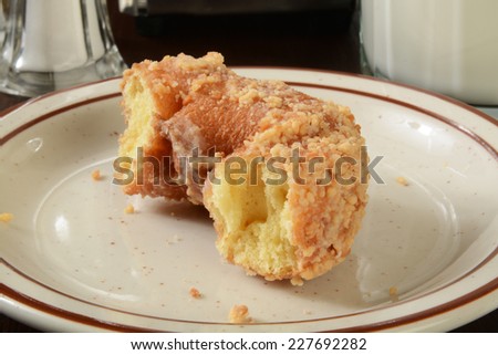 A half eaten cake donut with a glass of milk