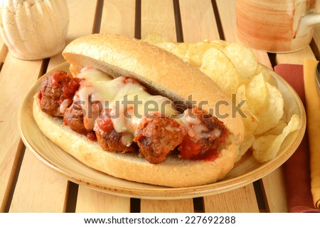 An Italian meatball sandwich in marinara sauce and topped with melted mozzarella cheese
