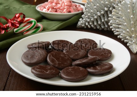 A plate of chocolate mint cream cookies with candy canes and peppermints for Christmas