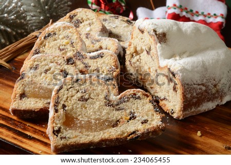 Sliced marzipan stollen on a cutting board with Christmas decorations