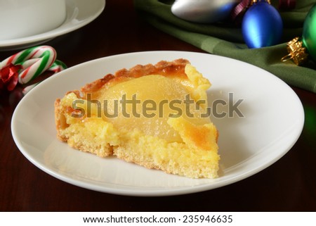 A slice of gourmet pear tart on a Christmas table