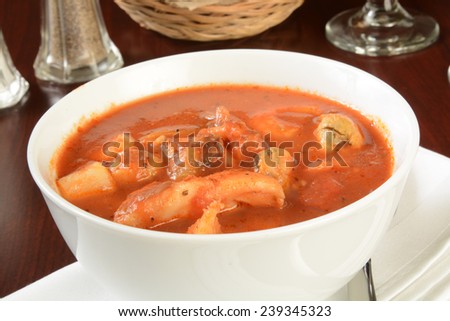 A bowl of hearty seafood stew or chowder in a tomato sauce