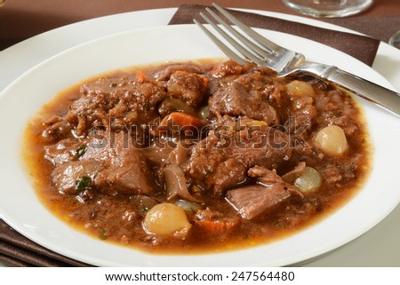 Slow cooked beef in burgundy wine sauce with pearl onions, mushrooms, carrots and spices