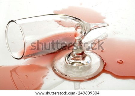 A broken wine goblet with burgundy wine