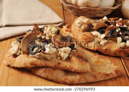 Naan bread with feta cheese, black olives, mushrooms for topping