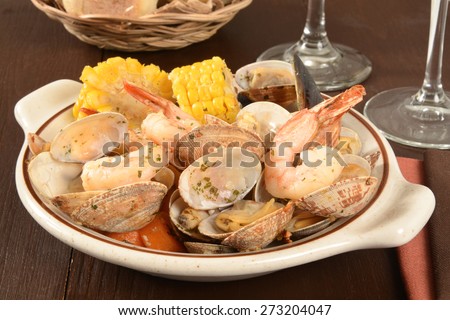 Clams, corn on the cob, shrimp and mussels in herbed garlic lemon butter sauce