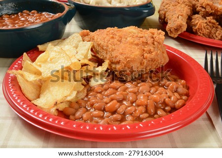 A picnic plate of fried chicken, Boston baked beans and potato chips