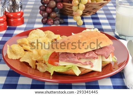 Roast beef and swiss cheese sandwich with potato chips