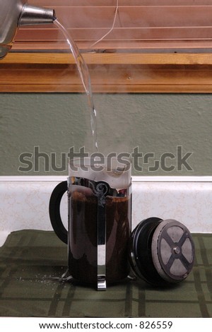 Steaming hot water is poured into a French coffee press.