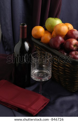 A gift basket of fruit and a bottle of wine.