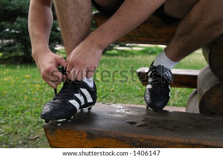a soccer player tieing his shoe