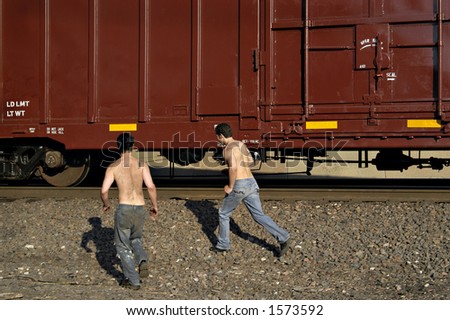 Two men running to hop a freight train