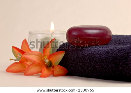Luxury soap, towels, flowers and a candle in a spa setup