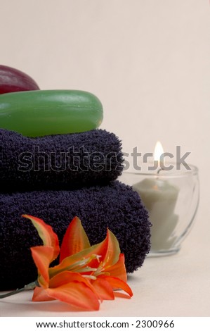 Luxury soap, towels, flowers and a candle in a spa setup