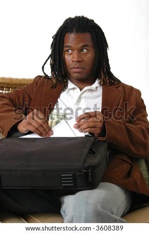 A young man slipping cash out of his briefcase