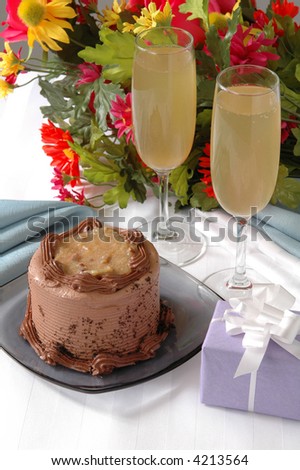 A German chocolate cake on a table with champagne and flowers