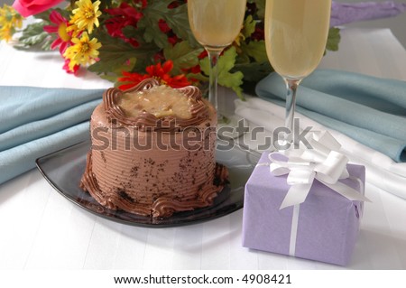 A german chocolate cake on a table next to a bouquet of flowers