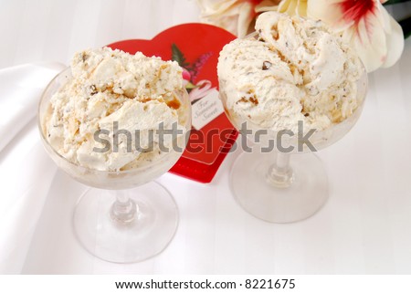 Two dishes of ice cream and a box of heart shaped chocolates