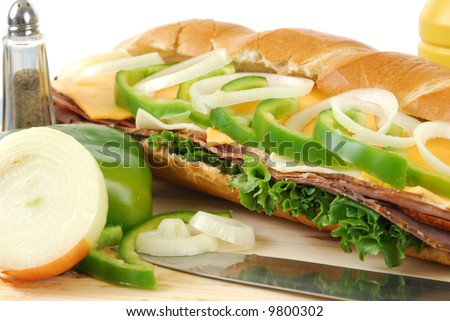 A cold cut sandwich with fresh green peppers and onion