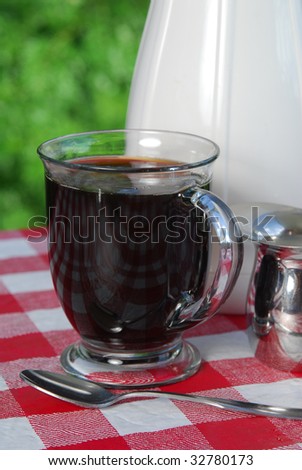 A cup of black coffee served on the patio