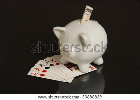 A piggy bank with money and a winning hand of cards