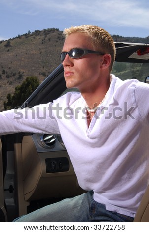 A young man getting out of his car in the mountains