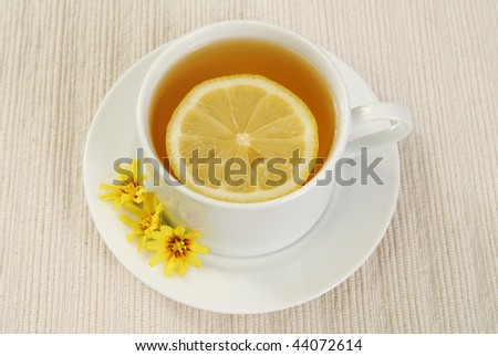 A cup of green tea with a slice of lemon on top